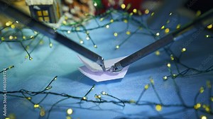 Artificial intelligence robot preparing snowflake from paper while preparing to the Christmas. Cropped view