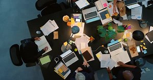 Collaboration, planning and teamwork in a busy office with corporate employee working late