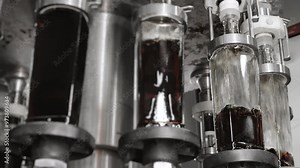 Automatic line for bottling drinks at the plant. Glass bottles are automatically filled with liquid. Bottling line for drinks, water and lemonades at the plant. Beverage production plant.