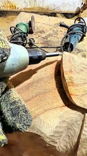 Carving wood surface using rotary tool in equipped workshop setting