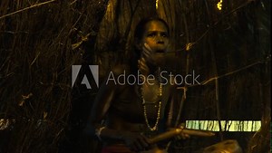 Yirrganydji Aboriginal woman play Aboriginal music with Clapstick, percussion musical Instrument made out of wood, during Aboriginal culture show in Queensland, Australia