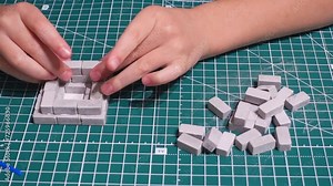Close-up, a child assembles a tower from blocks, a boy lays out a new level of the tower from small bricks. Children's educational toys.