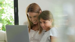 Woman with young girl using laptop computer