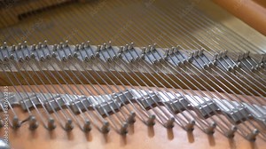 Aged grand piano's tight strings. Music instrument. Unique tonal qualities and role in classical and contemporary music. Tuning and repair of a musical instrument