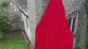 Thousands of knitted poppies cascade in remembrance tribute