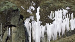 Iceland. Nature. The waterfall and the ice around it. Frozen winter landscape with snow and ice. Panoramic views of majestic ice waterfall. Icelandic golden circle tour