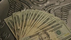 Stack of dollar bills of 20 over a country emblem - Free Stock Video