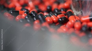 view of capsule medicine in a machine. automatic machine filling capsules pills in packing. pill making process in a pharma factory. medicine tablets in a machine. close up of tablet making process