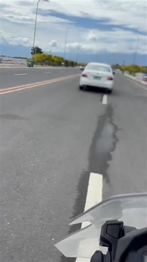 Sender: "I would like to report a traffic safety incident that occurred on Coastal Road near Ecoland Roundabout. A white Toyota Vios, which was traveling northbound, performed an illegal U-turn in a section marked with double solid yellow lines, then returned toward Ecoland Roundabout and exited onto Tulip Street. I was driving a motorcycle at the time, and I honked repeatedly to warn the driver, but he still executed the maneuver and ended up in our lane, creating a dangerous situation. My pass