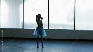 Barefoot young girl ballet dancing in silhouette