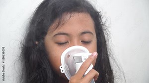 Little girl makes inhalation with a nebulizer. Children's asthma inhaler cough steam inhalation