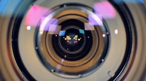 A macro view on a working video camera lens with inner rings seen inside.
