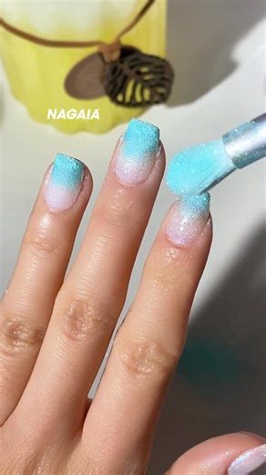 thenagaia on Instagram: "We created this Aurora vibe ombre using the flicking & dropping method. ❄️ Polar Prism: A crystalline snow-white infused with color-shifting aurora shimmer. 🌊 Arctic Teal: A refreshing aqua green reminiscent of frozen tropical waters. The 2026 Part II drop is bringing the “cool” back. 🧊💙 #nudenails #newnails #dipnails #ombrenails #glitternails"