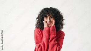 Frontal view of pretty Caucasian woman. Girl laughing and smiling while looking directly at camera. Placing both hands on face. Expressing emotions. Showing surprised facial expression.