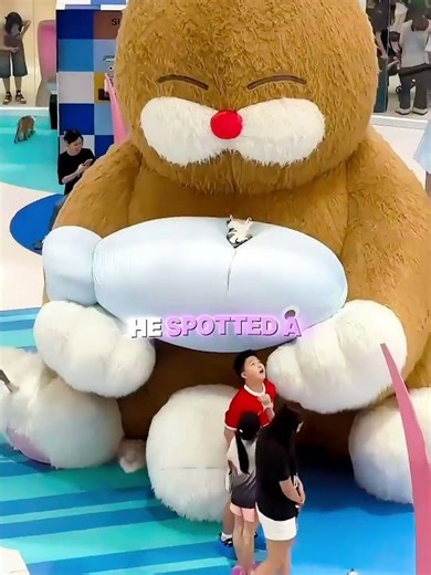 The kitten is playing with a giant stuffed animal