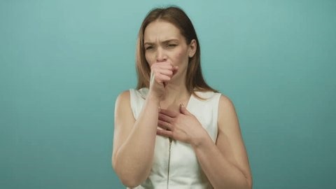 clip-4012052779-woman-coughing-into-fist-while-clutching-chest