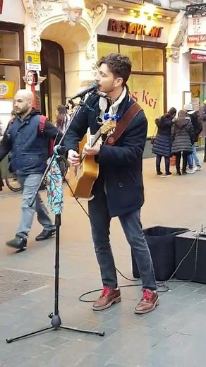 busker singing Bob Dylan song in London. blowin' in the wind