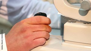 Eye examination test on a professional medical equipment screen, doctor adjusts medical equipment, Ophthalmologist works with a slit lamp