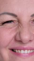 Close up view of playful pretty woman in overalls winking with eye...