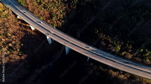 Aerial View of the Autobahn: Moving Cars and Summer Countryside Road in Austria, captured from a drone’s perspective, with the stunning wild forests of Austria in the background. Austria aerial