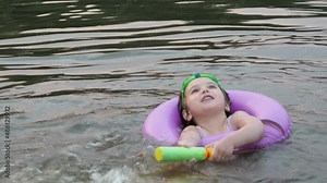 happy children, boy and girl swim in a forest lake. splashing each other. play. enjoying vacations and outdoor recreation. in blue water at sunset; bathe in lake or river and making water drops