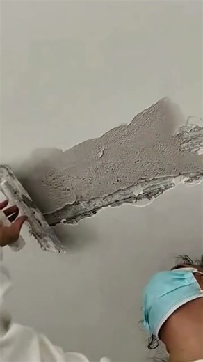 Repairing damaged wall plaster with smooth finishing strokes
