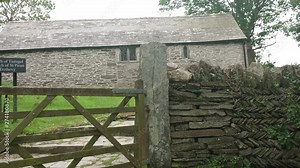 The Chapel of Saint Piran is a long construction in Trethevy, in the anglican parish of Tintagel in Cornwall, Uk. A church surrounded by farm buildings and converted barns. Zoom in 4k footage
