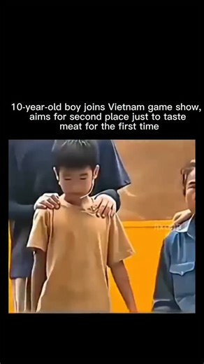 Virendrabhai Rathva on Instagram: "This is a short, emotional clip (about 17 seconds) from what appears to be a Vietnamese outdoor game show or charity event, overlaid with English text: "A 10- Year-Old Joined Just to Taste Meat for the First Time " (with some typos in the subtitles). It opens with a young boy, around 10 years old, wearing a simple beige t-shirt, standing nervously under yellow event tents amid a crowd and banners for sponsors like "Beecom" and "Lusta." Two adults gently place t