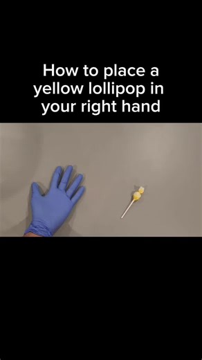 To place a yellow lollipop in your right hand, begin by locating the lollipop and ensuring it is unwrapped or ready to hold. Extend your right hand with your palm facing upward and your fingers slightly open. Using your left hand, gently grasp the stick of the lollipop near its base, then position it over your right palm. Carefully lower the stick into your right hand, allowing your fingers to curl around it naturally. Adjust your grip so the stick rests comfortably between your thumb and finger