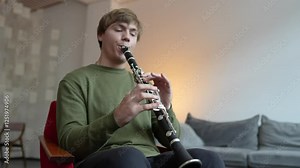Passionate man musician intensely playing clarinet, seated in chair of music classroom. Instrument mastery, wind instrument performance, man emotional artistry, tonal precision and breath control