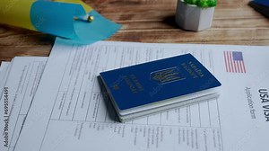 Close up shot of person identity document. Application for moving to usa and ukrainian passport laying on the table, document for visa applicant.