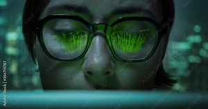 Pretty woman working on laptop wearing eyes glasses with programming matrix source code and cyberspace symbols reflection. Virtual reality matrix concept.