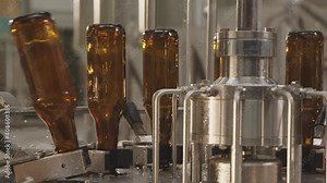 Close-up of brown bottles on a bottle washing machine. Bottle cleaning process in a factory. Modern bottle washing machine. Factory, brewery concept.
