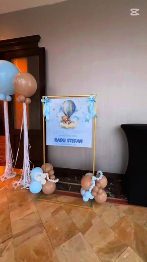 Un decor de poveste pentru botezul micutului Radu-Stefan 🤍 Photocorner grandios cu ghirlande profesionale de baloane in tematica hot air balloon teddy, in tonuri calde de bej si baby blue, lampi stea, reflectoare, baloane texturate si transparente, cuburi decorative si numele personalizat care completeaza perfect atmosfera ✨ Mesele invitatilor au fost puse in valoare de suporti delicati si romantici cu brate transparente, lumanari LED in vase de sticla si fire de flori real touch in nuante de a