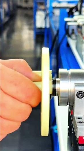 Plastic gear aligned onto metal shaft in workshop
