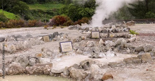 A large bubbling volcanic hot spring pond splashing water and steam at Furnas, Azores.
