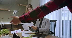 Multicultural employees going through paperwork, analyzing and discussing growth charts or statistics in a modern office setting, highlighting teamwork and collaboration.