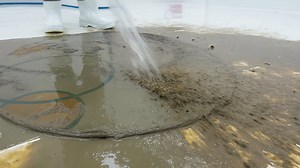 Rinsing mud to reveal a rug pattern