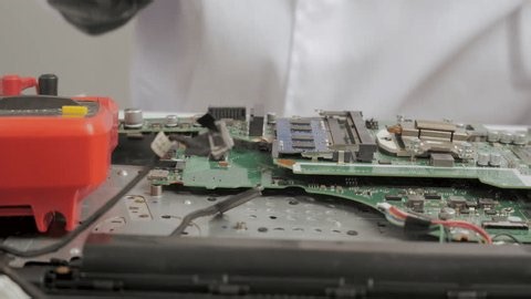 clip-3978022159-technician-installing-memory-module-on-laptop-motherboard