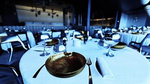 Empty restaurant setting with elegant tableware and dim lighting ambiance