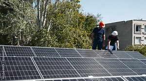 A chief engineer oversees the installation of solar panels on a rooftop. The scene highlights expert supervision and modern renewable energy solutions in action.