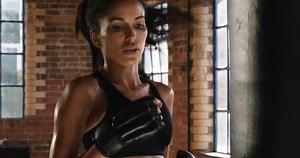 Beautiful Kickboxing woman training punching bag in fitness studio fierce strength fit body kickboxer series