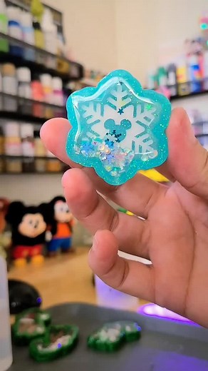 This charm reminds me of the Christmas Disney commercials! ❄️ Mickey snowflake charms are now available! Snag yours now as a phone grip, badge reel or keychain and get ready for the most wonderful time of year! ❄️ #disneyland #disneyaddict #snowflakes #christmasaccessories #holidayseason #shopsmall #winterseason #resinart #badgereels #bagcharm #phonecharm | Resin Drops of Sunshine