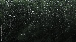 Close-up, Raindrops on glass on a dark background. Background with rain texture outside the window. Climat is changing. Beautiful summer rain outside the window