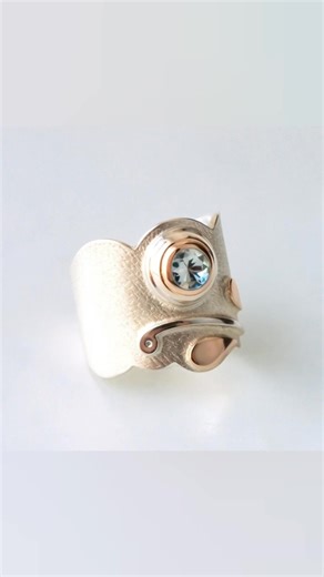 Žydėjimas 🌿💎 Žiedas. Sidabras, auksas, topazas. Šis žiedas – apie akimirką, kai viskas ima busti. Švelnus topazo mėlis čia švyti lyg mažas, dar gležnas pumpuras, kupinas tyros, ramios energijos. Šilkinė sidabro faktūra — švelni tarsi žiedlapio paviršius. Auksas įsilieja subtiliais šiltais atspalviais, lyg pirmieji saulės blyksniai, paliečiantys ką tik prasiskleidusį žiedą. „Žydėjimas“ – žiedas apie natūralų grožį ir švelnų virsmą, kuris įvyksta, kai šviesa pagaliau pasiekia širdį. DEA Jewelry 