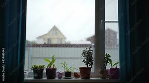 view of the window during a downpour against the backdrop of a rural landscape