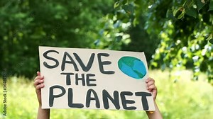 Young kid child holding in hands green posters at global climate strike. youth protesting for safe ecology,global warming and pollution, plastic in public demonstration. Climate Strike. Eco Activism