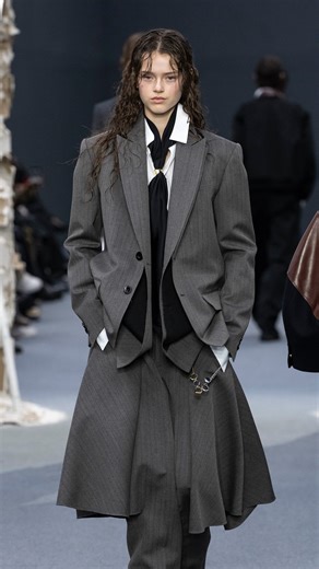 Vogue Philippines on Instagram: "At @lecarreaudutemple, #Sacai (@sacaiofficial) staged its men’s and women’s fall 2026 collections as a rain-soaked study in hybridization. #ChitoseAbe honored Muhammad Ali with what she called the “uniform of a champion,” weaving boxing references into softly deconstructed tailoring. Oversized robe-like outerwear with sash belts, satin and silk nods to boxing trunks, and Ali’s mantras appeared across hybrid silhouettes, from shorts over trousers to skirt–pant con