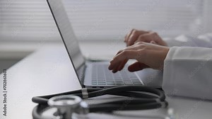 A medical specialist keeps detailed records of patient symptoms in an online database, creating a complete report for further study and treatment. Close-up of hands typing on keyboard
