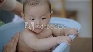 Young mom shower baby , Baby asian happy moment with mom at living room. asian family with newborn